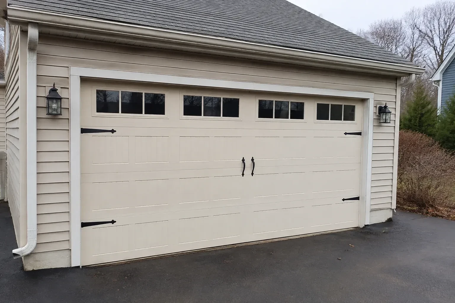 Cream carriage-house-style garage door with dark decorative hardware. — Carriage-House Garage Door Installation, Vaughan